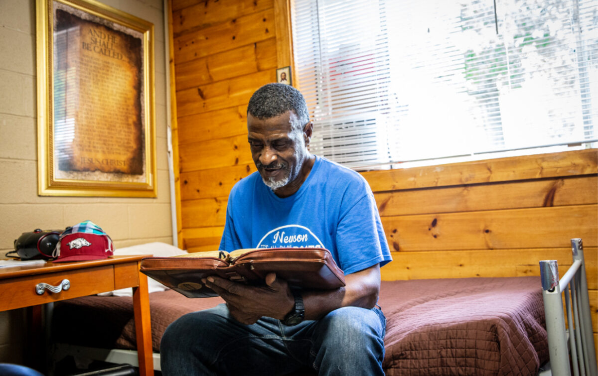 A Warriors Center resident reading his Bible in his room