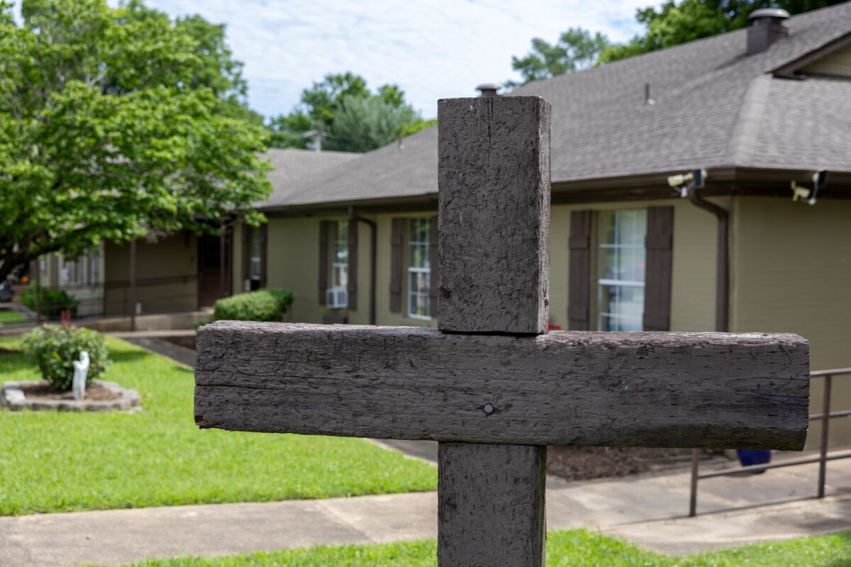 A Warriors Center campus building with a wooden cross in the front yard