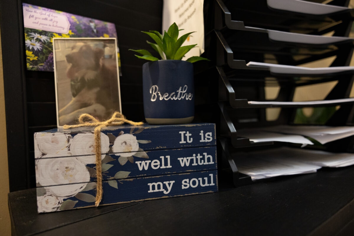 An office desk at a Warriors Center campus with a sign reading It Is Well With My Soul