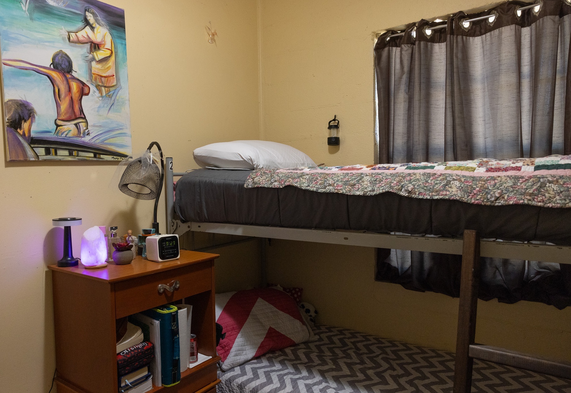 A made bed waiting in a resident room at the Warriors Center