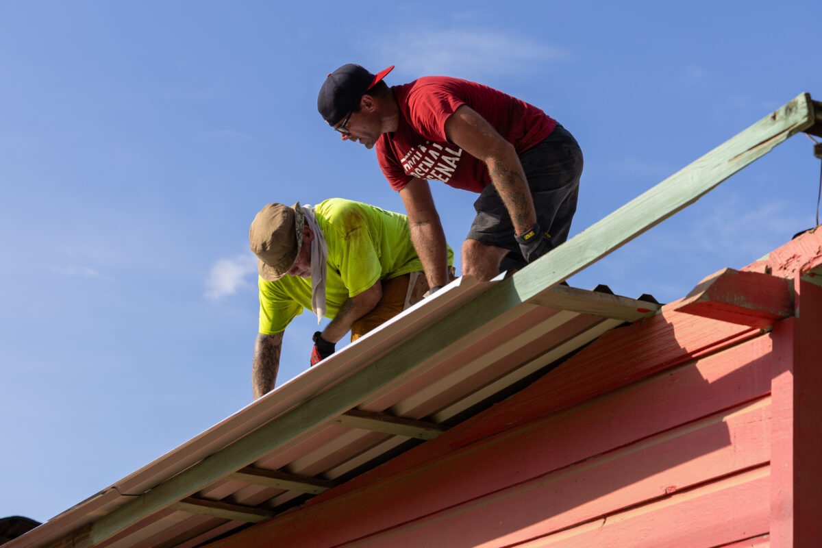 Two mission team members installing a metal roof in Honduras
