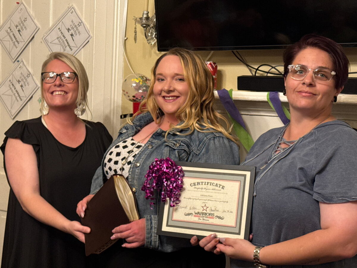 Adrianna Pease receiving her graduation certificate from Destiney Baskins and Jodi LaRose